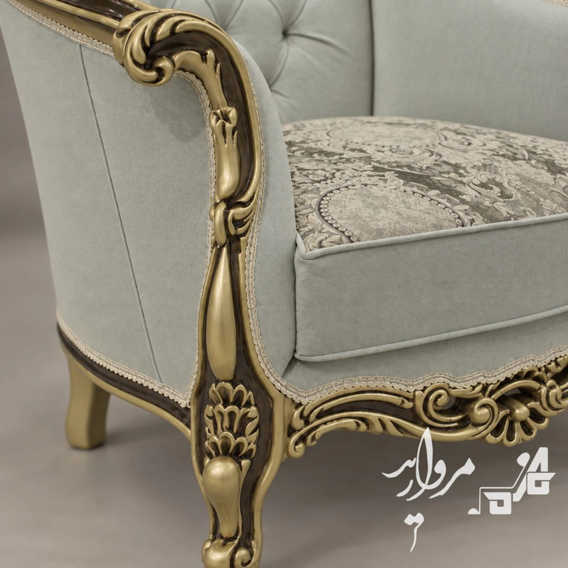 جزئیات منبت‌کاری طلایی با گودی گردویی روی دستهٔ مبل کلاسیک پریسان، کنار نشیمن پارچهٔ ژاکارد