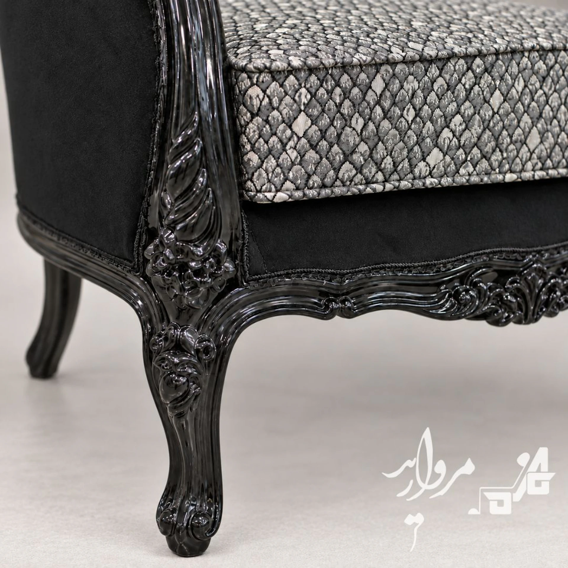 نمای نزدیکِ پارچهٔ ژاکاردِ فلسیِ مشکی‌ونقره‌ای، مخملِ مات و منبتِ لاکِ براقِ پایهٔ مبل کلاسیک مرجان مشکی